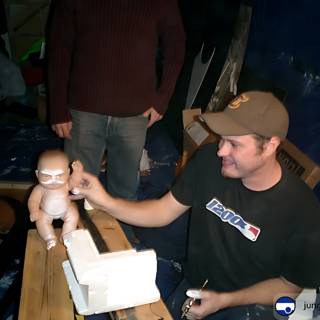 Man and Doll in front of Wooden Table