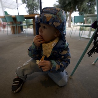 Toddler Enjoying Snack at Outdoor Cafe
