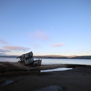 Abandoned Shipwreck at Twilight on Coastal Shore