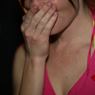 Woman Covers Mouth in Surprise at Event