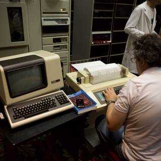 Man at Desk with Computer and Typewriter