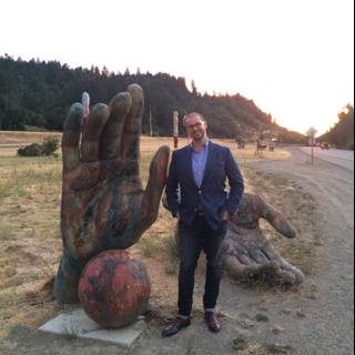 The Man and the Giant Hand Sculpture