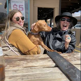 Two Women and Their Furry Companion Enjoy Waterfront Dining