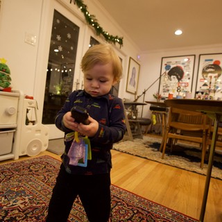 Toddler Examining Toy in Cozy Christmas Home