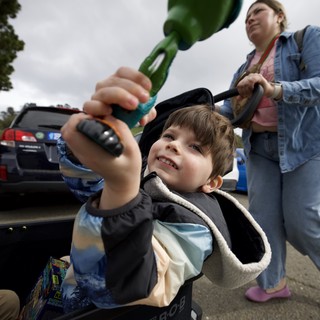 Young Boy with Dinosaur Toy at Parking Lot Gathering