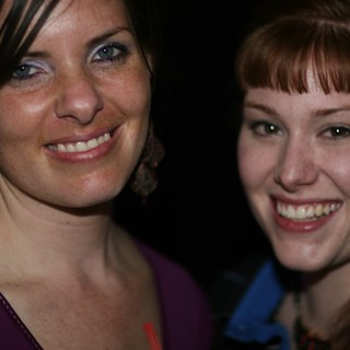 Two Smiling Women at a Nighttime Social Event