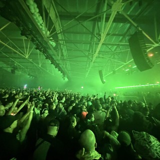 Massive Crowd Under Green Laser Lights at Electronic Music Concert