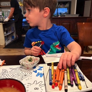Young Boy Coloring with Crayons at Home