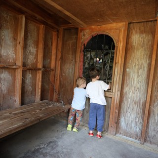 Two Children Peering Through Barred Window at Fantasyland