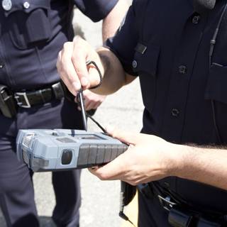 Police Officer Examining Car with High-Tech Device