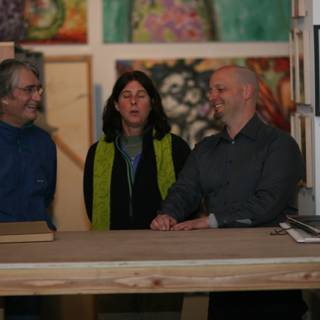 A Trio of Art Lovers in Front of a Plywood Table