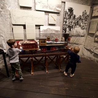 Children Exploring Historic Train Exhibit in Museum