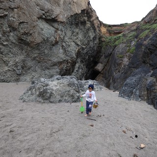 Young Explorer Discovers Sea Cave on Rocky Beach