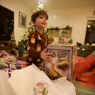Christmas Morning Joy: Boy Opening Dinosaur Gift