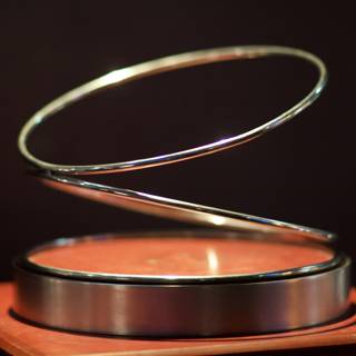 Gleaming Silver Ring on Wooden Stand