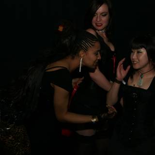 Three women in black corsets and stockings dancing at a night club