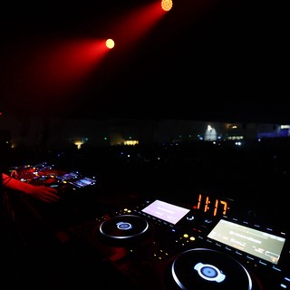 DJ Drops Bass Under Red Stage Lights at Night