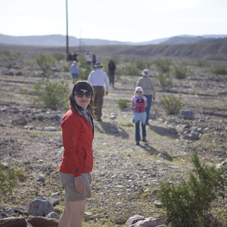 Desert Hiker Pauses on Rocky Trail Amid Group