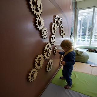 Child Exploring Interactive Gear Wall Installation