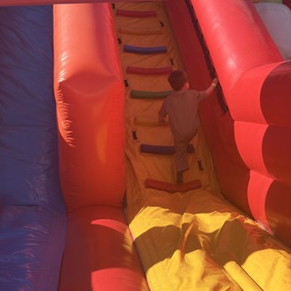 Child Climbing Through Inflatable Bounce House Obstacle