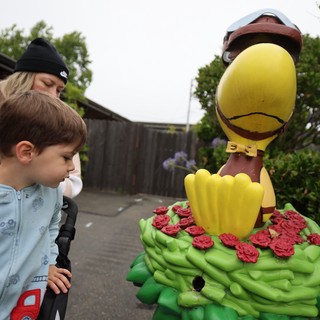 Child's Wonder at Colorful Duck Mascot Statue