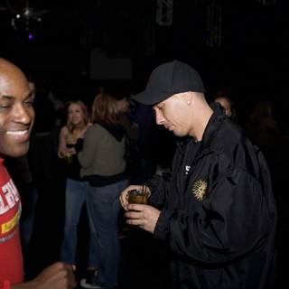 Man in Red Shirt and Black Hat Sips Drink at Funky Funktion Party