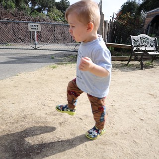 Toddler Running Joyfully Through Sandy Play Area