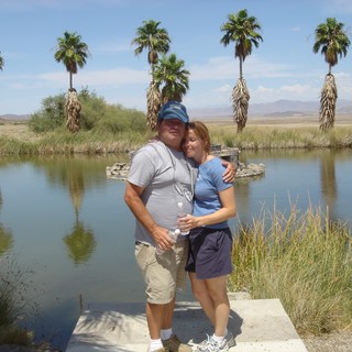 Couple Embracing at Desert Oasis Pond