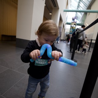 Toddler Playing with Blue Fidget Toy at Museum