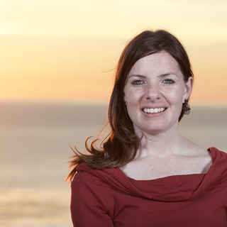 Radiant Woman Smiling at Golden Hour Beach