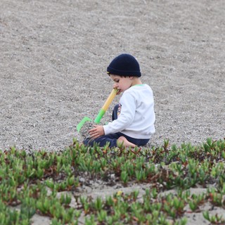 Young Child Playing Alone on Sandy Beach