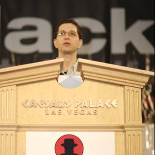 Jeff M delivering a speech in front of Black Hat sign
