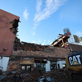 Demolished Building Under Clear Blue Sky with CAT Excavator