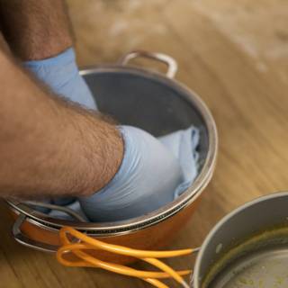 Cleaning a Pot with Blue Gloves