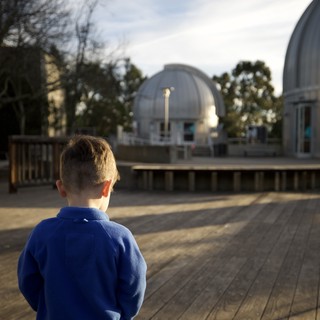 Young Boy Gazing at Observatory Domes at Dusk