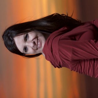 Woman Smiling Against a Vibrant Sunset Sky