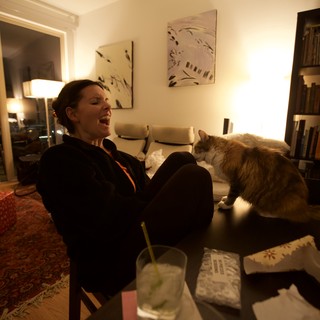 Laughing Woman and Cat Share a Cozy Evening