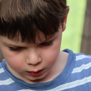 Young Boy in Blue Striped Shirt Looking Down