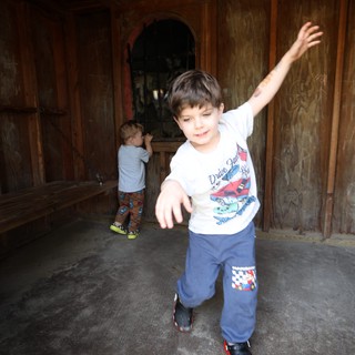 Young Boy Dancing in Rustic Wooden Room