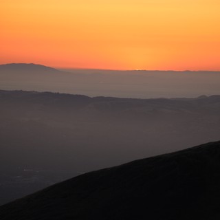 Layered Mountain Silhouettes at Fiery Sunset Dusk