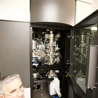 Man Examining Optical Equipment in a Technical Setting