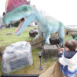 Child Confronts Colorful Spinosaurus at Dinosaur Park