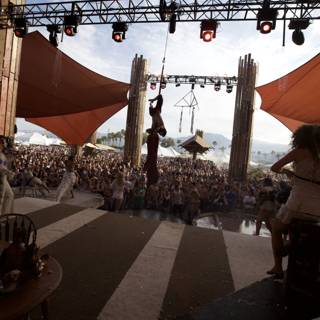 Man on Stage with Bikini-Clad Woman at Coachella Concert