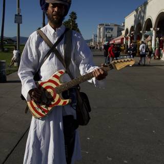 Turbaned musician strums the guitar under a Palm tree