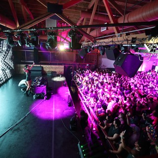 Packed Dance Crowd Pulses Under Violet Stage Lights
