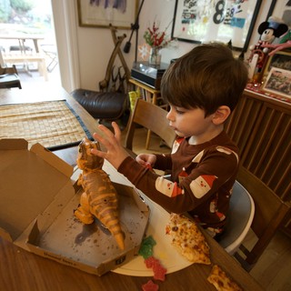 Young Boy's Delighted Dinosaur Pizza Discovery on Christmas