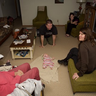 Family Gathering Around Newborn Baby in Living Room