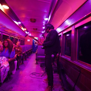 Live Music Performance in Purple-Lit Vintage Train Car