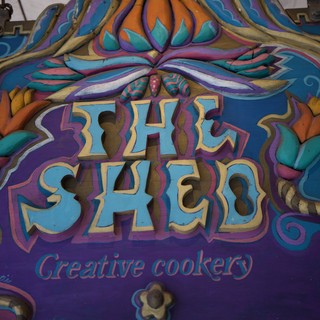 Colorful Hand-Carved Shed Sign with Ornate Design
