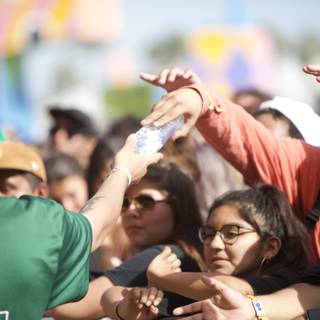 Man giving water to thirsty Coachella crowd
